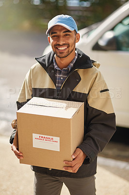 Buy stock photo Shot of a delivery man loading boxes into a vehicle
