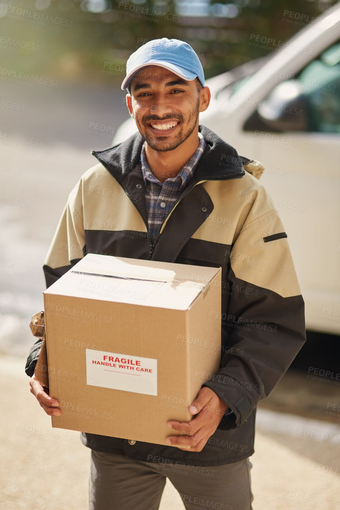Buy stock photo Shot of a delivery man loading boxes into a vehicle