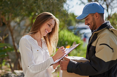 Buy stock photo Shot of a courier delivering a package to a smiling young woman at home