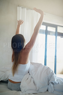 Buy stock photo Rearview shot of an unidentifiable woman waking up rested in her bed at home