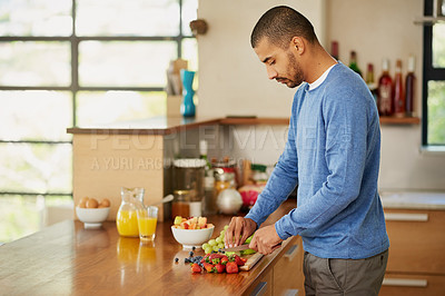Buy stock photo Shot of a young man preparing a healthy snack at home
