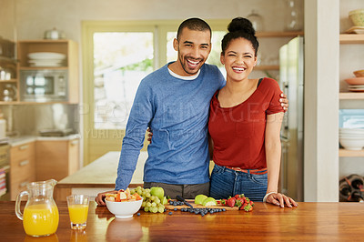 Buy stock photo Portrait of a happy young couple preparing a healthy snack together at home