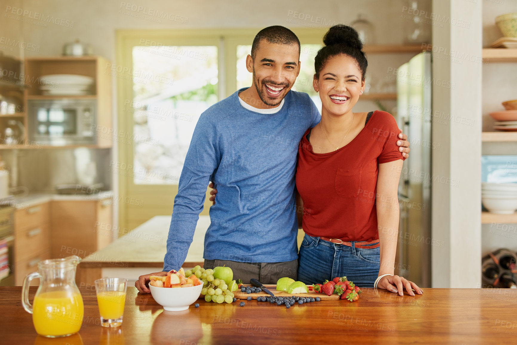 Buy stock photo Portrait of a happy young couple preparing a healthy snack together at home