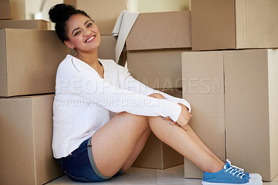 Buy stock photo Portrait of a happy young woman sitting among cardboard boxes while moving house