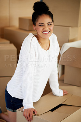 Buy stock photo Portrait of a happy young woman kneeling among cardboard boxes while moving house