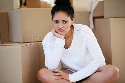 Buy stock photo Portrait of a young woman sitting on her own while surrounded by cardboard boxes