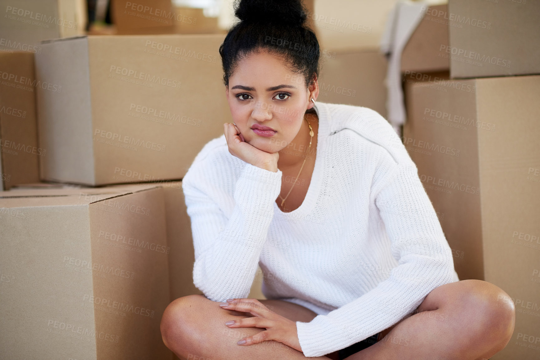 Buy stock photo Portrait of a young woman sitting on her own while surrounded by cardboard boxes