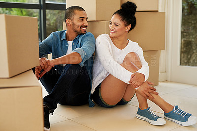 Buy stock photo Shot of a happy young couple sitting among cardboard boxes in their new home