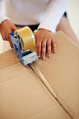 Buy stock photo Shot of an unidentifiable young woman packing boxes while moving house