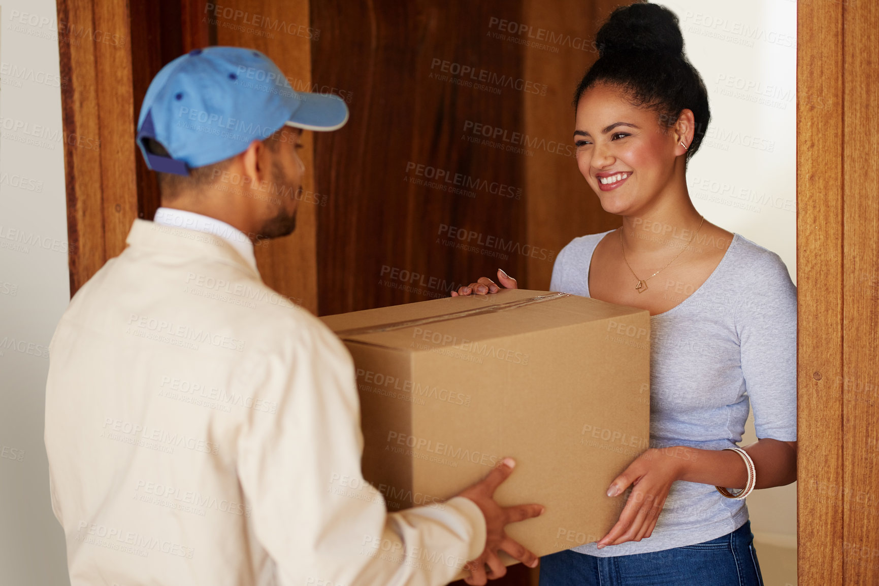 Buy stock photo Shot of a delivery man making a delivery to a customer at her home