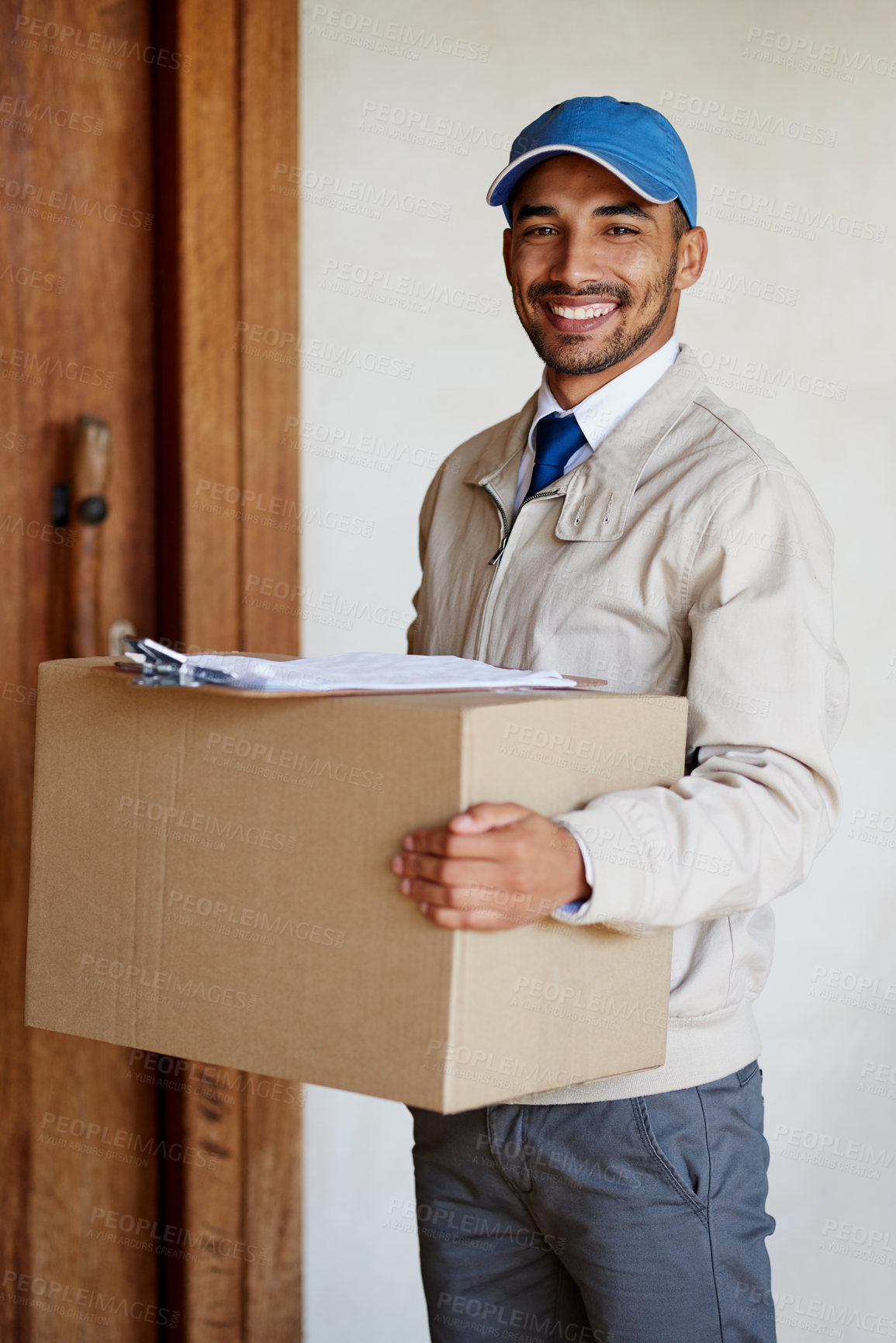 Buy stock photo Portrait of a friendly delivery man delivering a box to a customer's door
