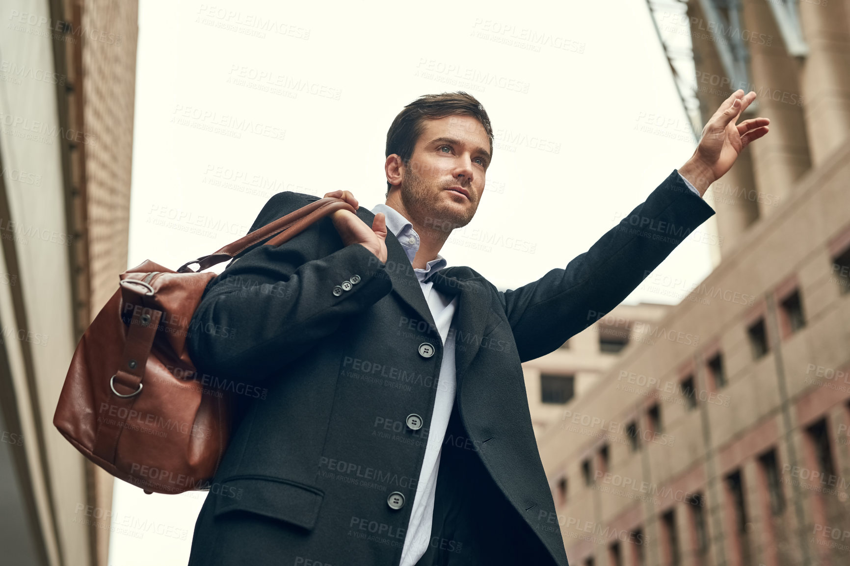 Buy stock photo Cropped shot of a young businessman gesturing to get a cab in the city