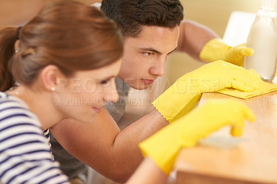 Buy stock photo Shot of a happy young couple cleaning their kitchen together