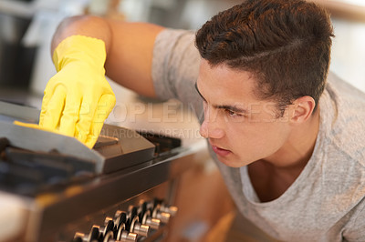 Buy stock photo Shot of a focused young man cleaning his kitchen