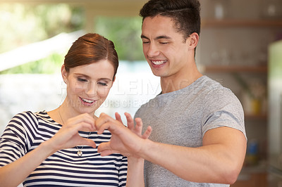 Buy stock photo Shot of an affectionate young couple bonding in their kitchen at home