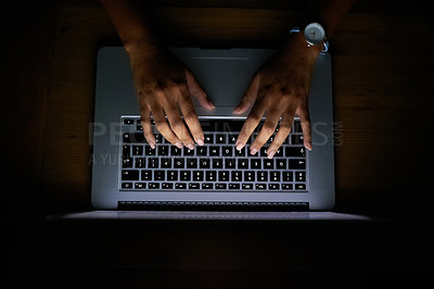 Buy stock photo High angle shot of a woman working late on a laptop against a dark background