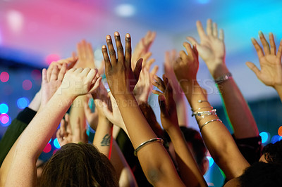 Buy stock photo Shot of a group of friends dancing with their arms raised in a nightclub