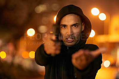 Buy stock photo Portrait of a gun-wielding thief aiming his weapon in the city