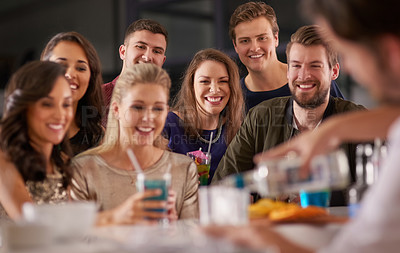 Buy stock photo Shot of a happy group of friends having drinks at a bar together