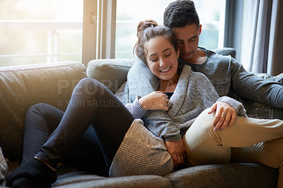 Buy stock photo Shot of an affectionate young couple relaxing on the sofa at home