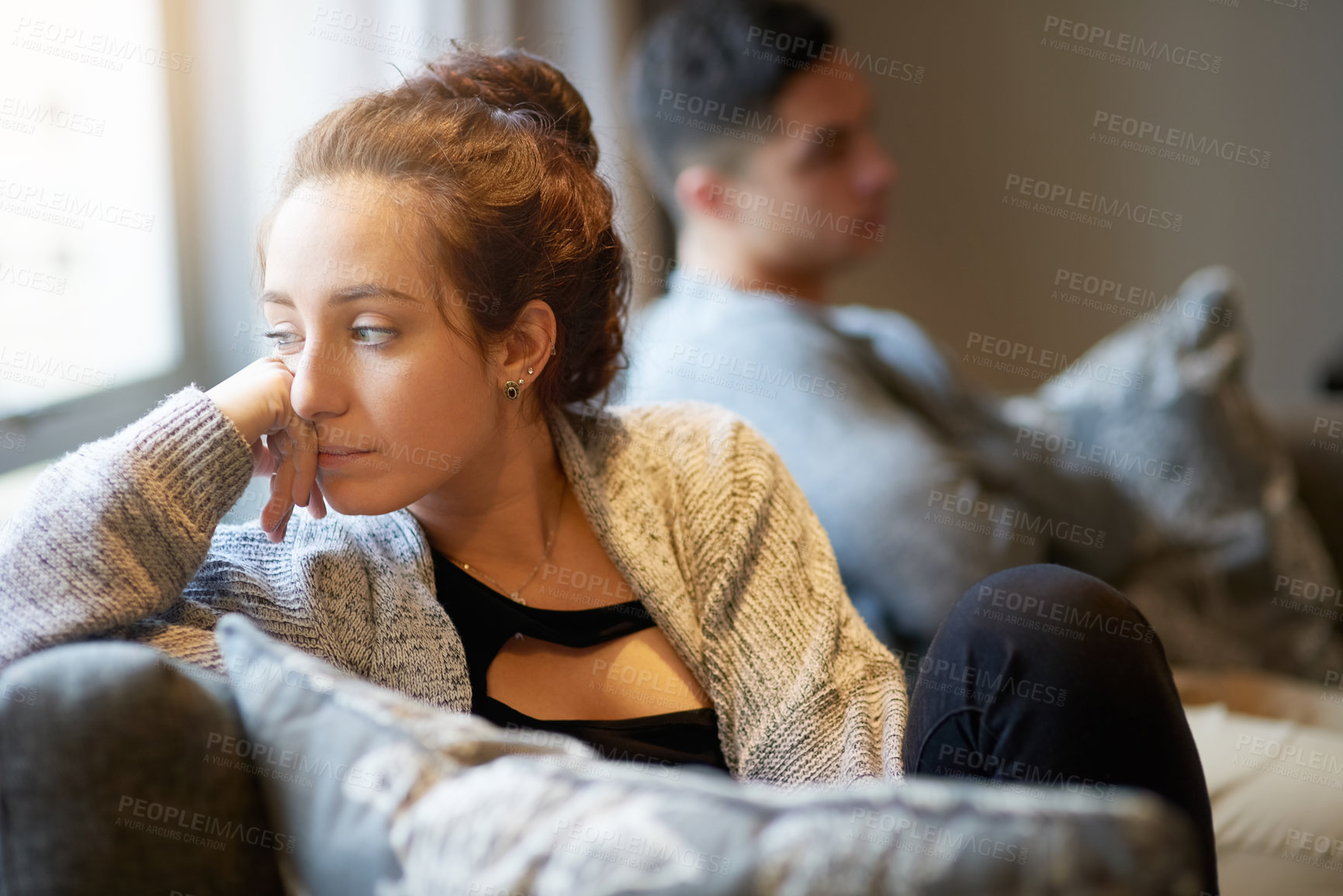 Buy stock photo Shot of a young woman looking despondent after a fight with her boyfriend