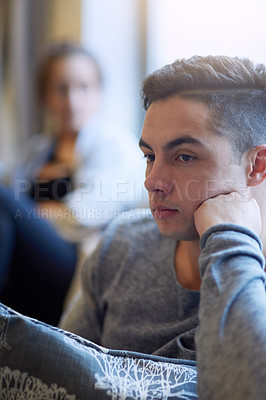 Buy stock photo Shot of a young man looking despondent after a fight with his girlfriend