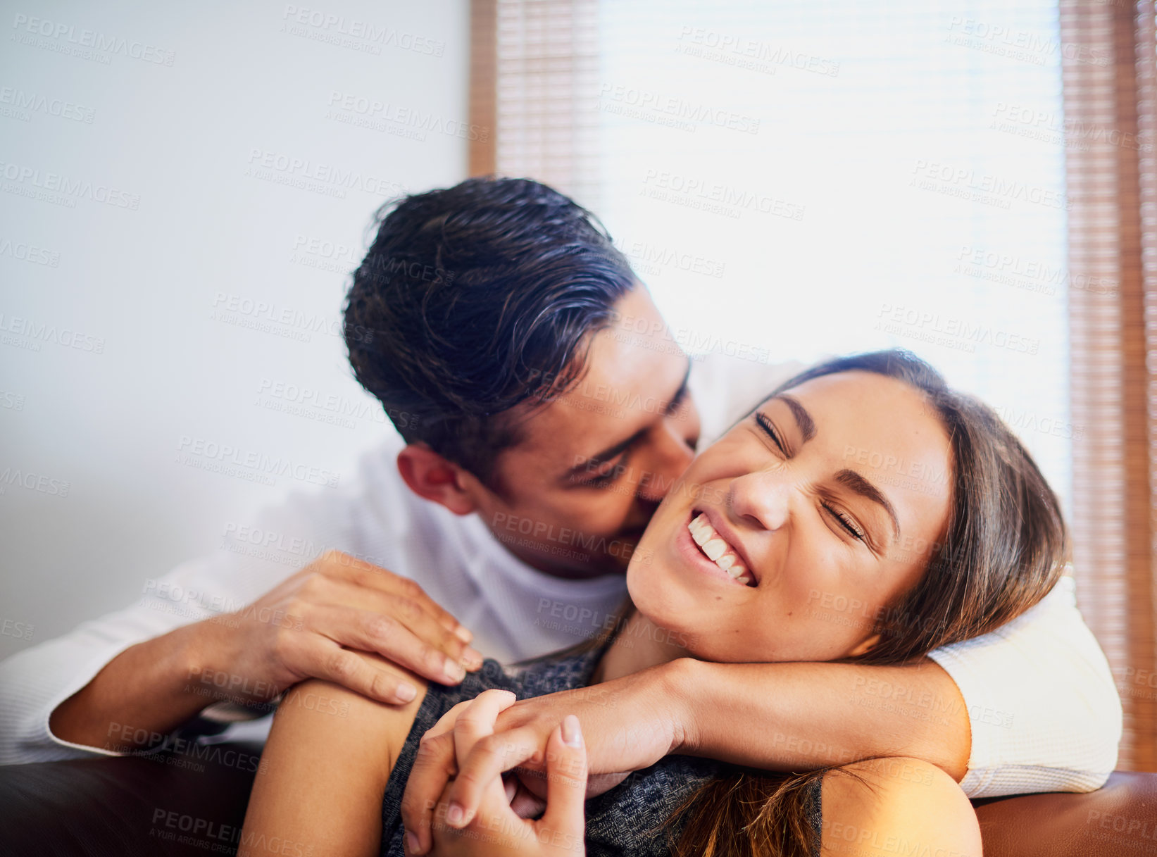 Buy stock photo Shot of a laughing young couple sharing a moment together at home