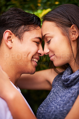Buy stock photo Closeup shot of a smiling young couple embracing face to face outside
