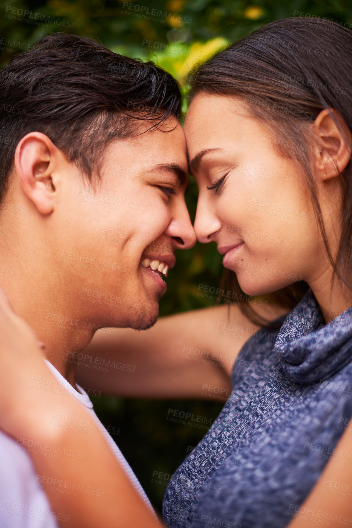 Buy stock photo Closeup shot of a smiling young couple embracing face to face outside