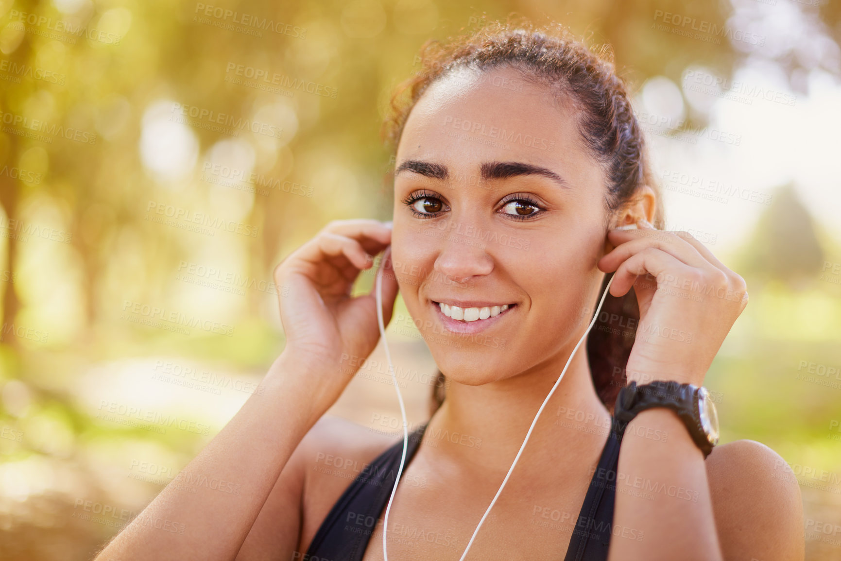 Buy stock photo Shot of a sporty young listening to music while working out outdoors