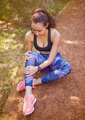 Buy stock photo Shot of a sporty young woman suffering from a knee injury
