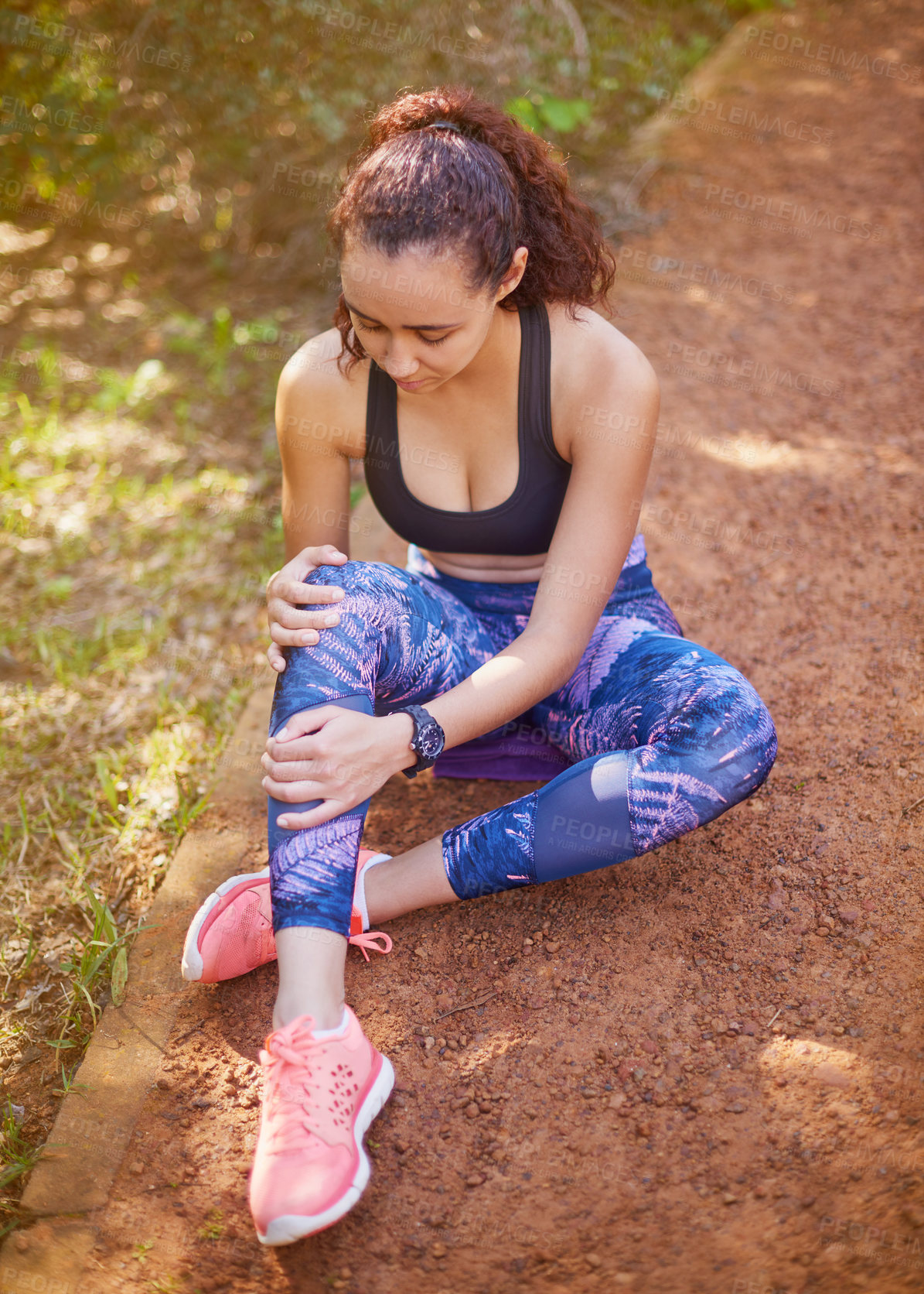 Buy stock photo Shot of a sporty young woman suffering from a knee injury