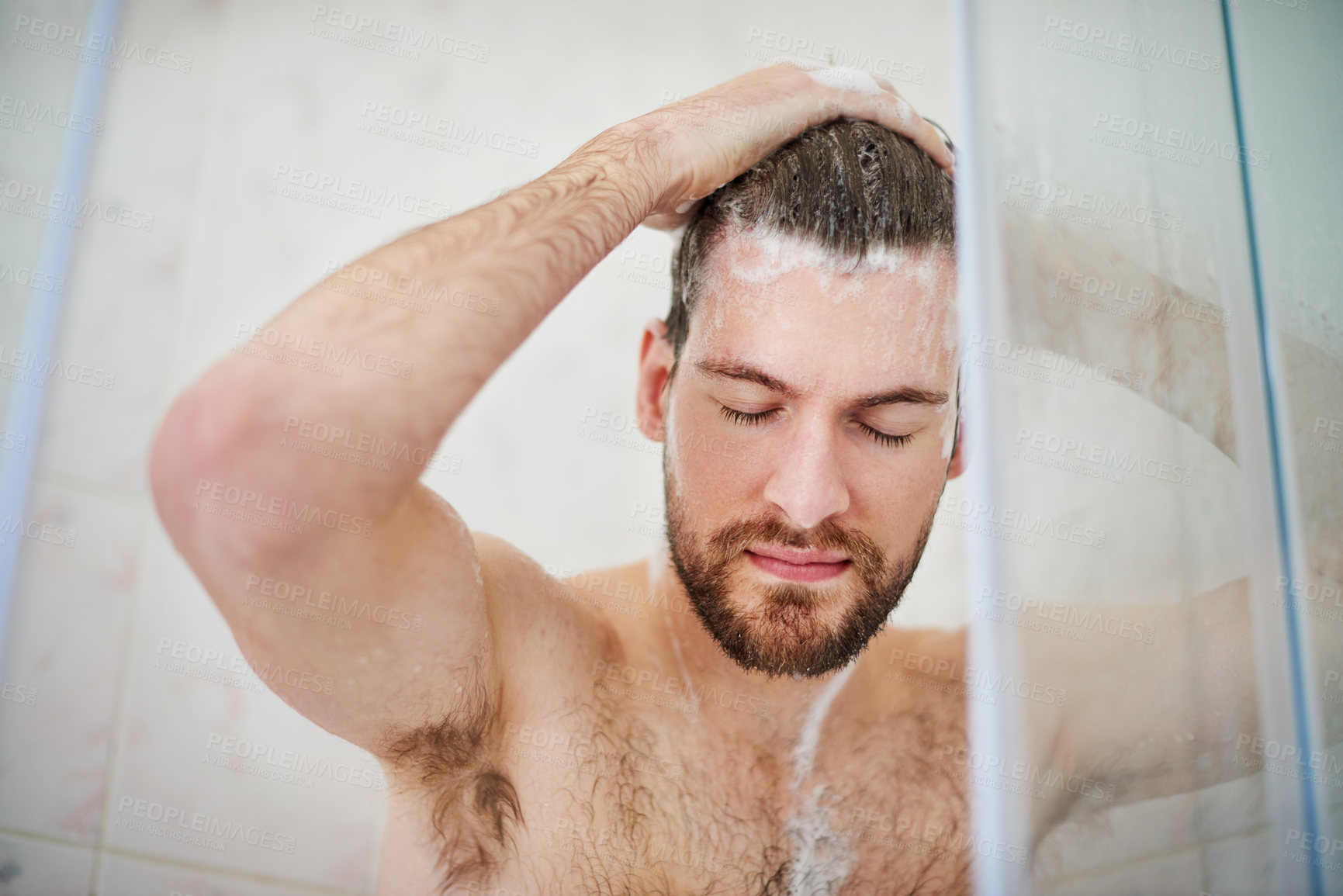 Buy stock photo Cropped shot of a handsome young man having a shower at home