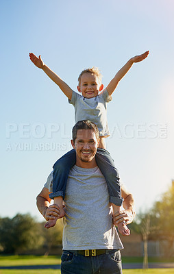 Buy stock photo Shot of a father carrying his little son on his shoulders while enjoying a day in the park together