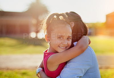 Buy stock photo Portrait of a smiling little girl hugging her mother while enjoying a day together in the park
