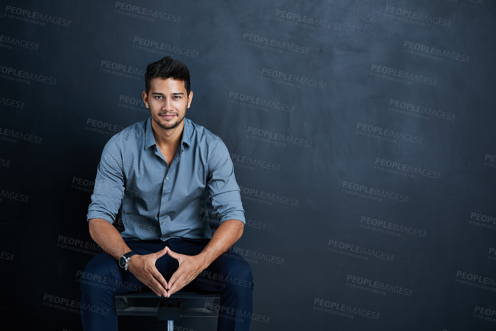 Buy stock photo Studio portrait of a confident young businessman posing against a dark background