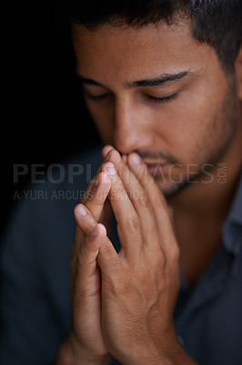 Buy stock photo Cropped shot of a young man holding his hands together in prayer