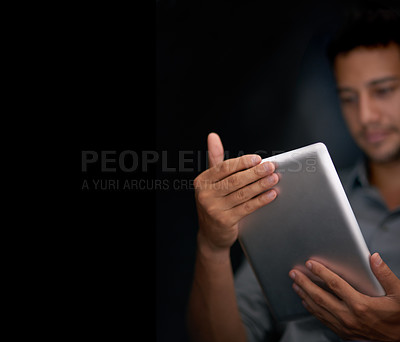 Buy stock photo Cropped shot of a young man using his tablet at night