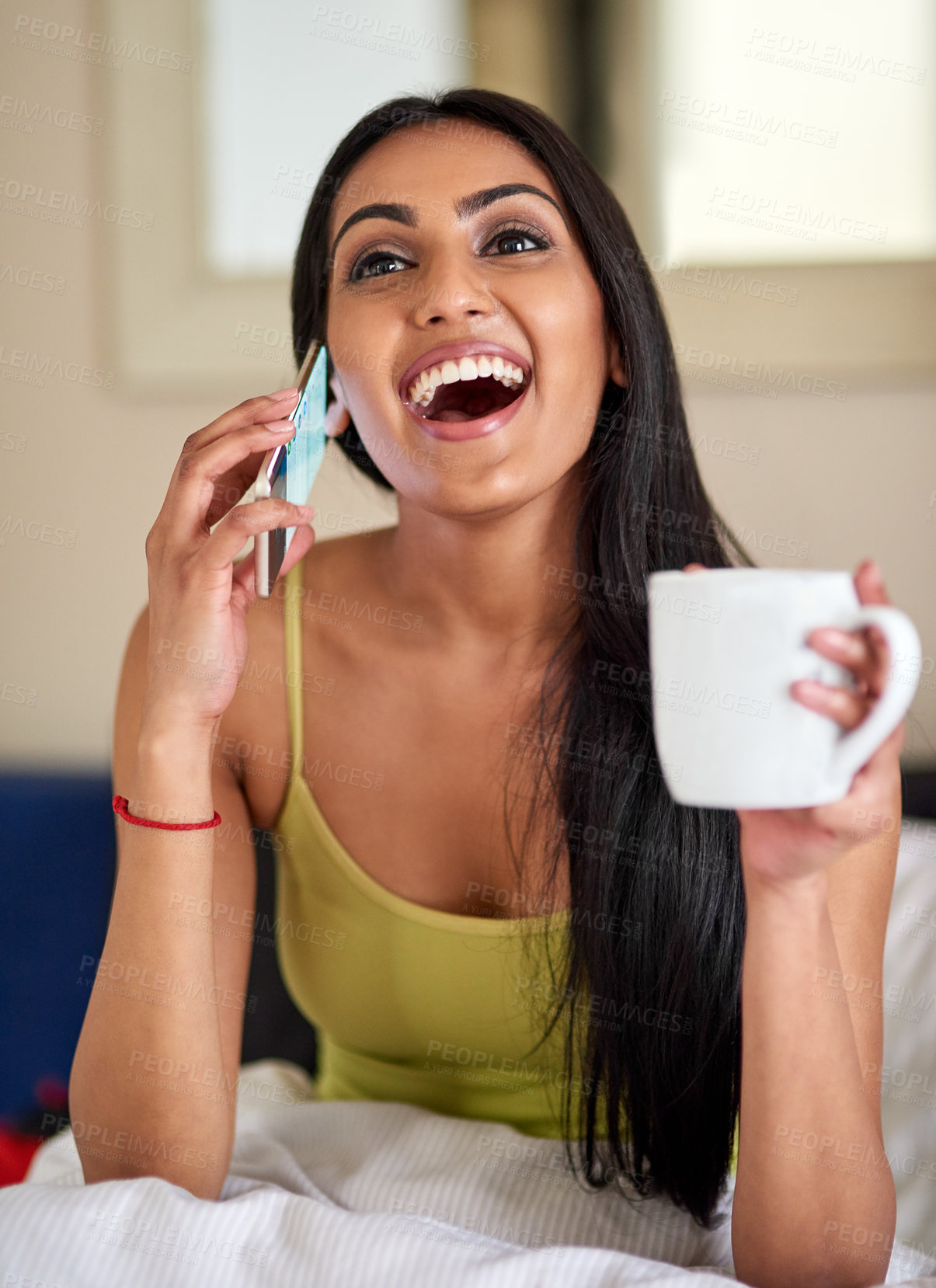 Buy stock photo Shot of a happy young woman talking on the phone in bed