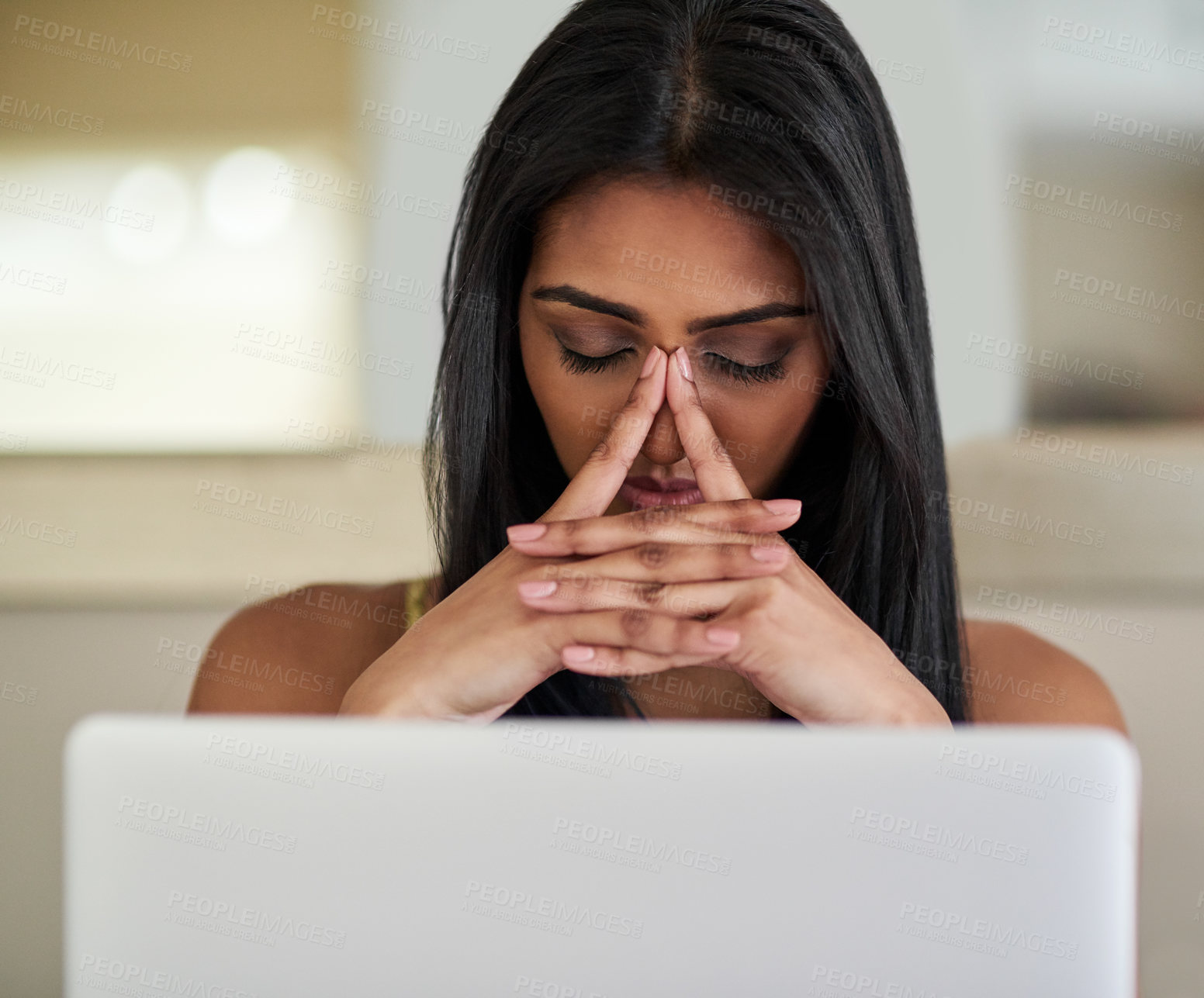 Buy stock photo Shot of young woman looking stressed while using a laptop
