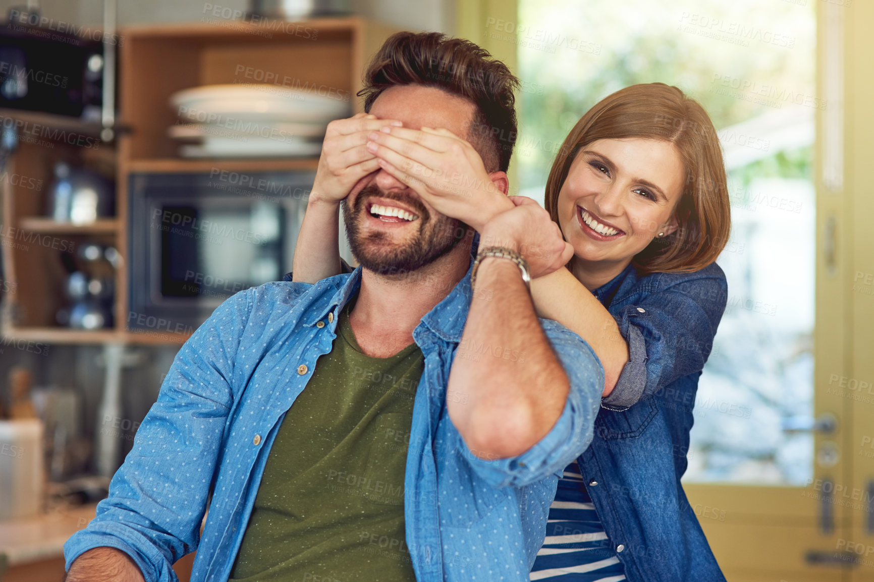 Buy stock photo Portrait of a happy young woman playfully covering her husband’s eyes