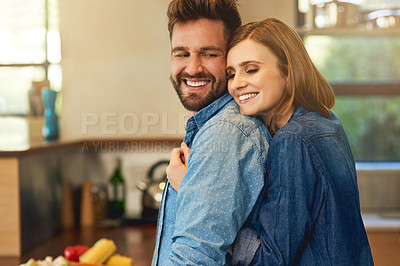 Buy stock photo Shot of a happy young couple sharing an affectionate moment in the kitchen at home