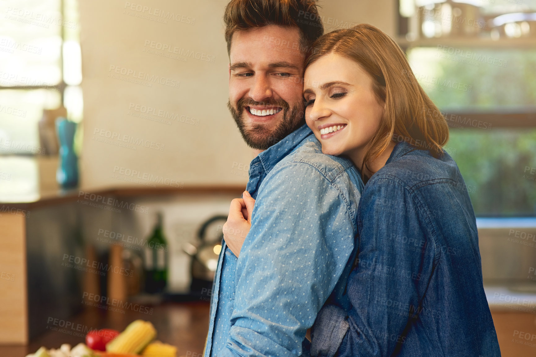 Buy stock photo Shot of a happy young couple sharing an affectionate moment in the kitchen at home