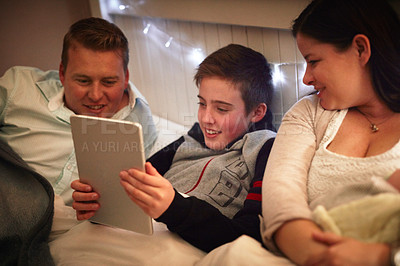 Buy stock photo Shot of a family reading together at home