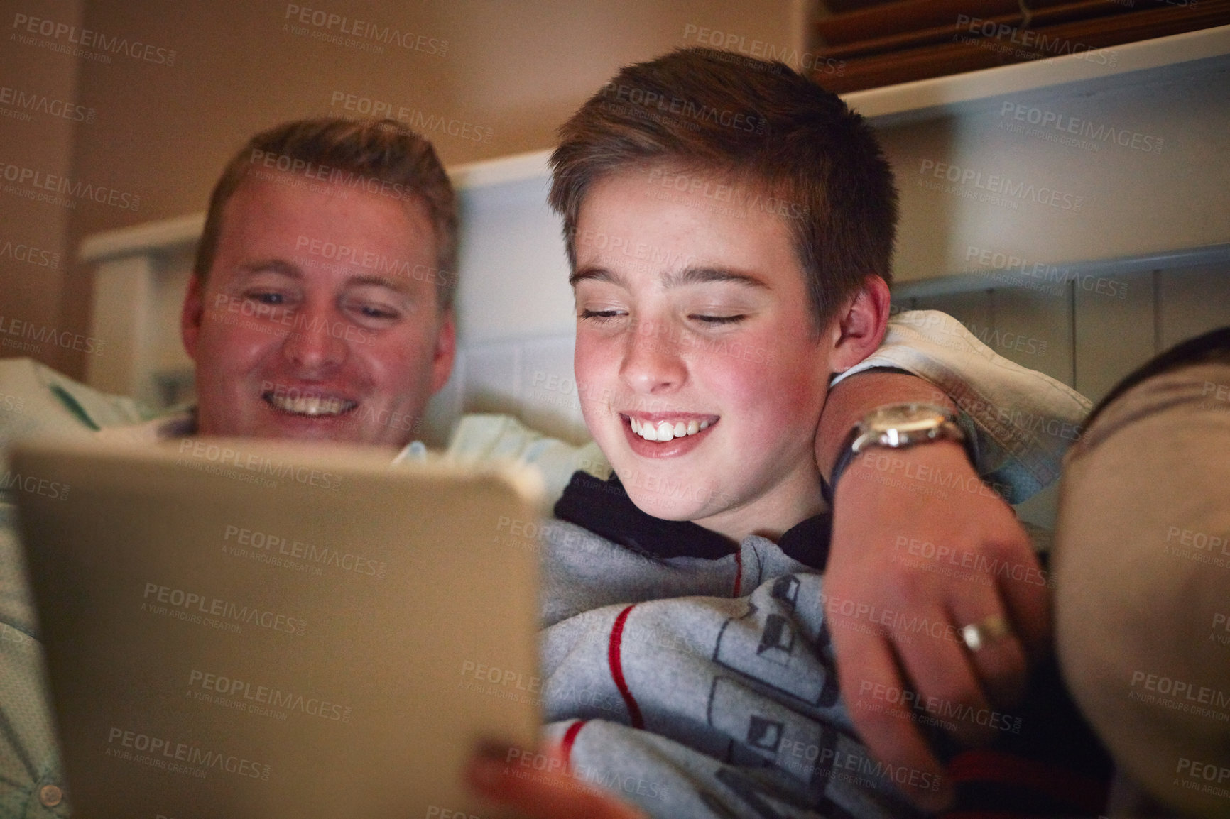 Buy stock photo Cropped shot of a father and son using a digital tablet together at night