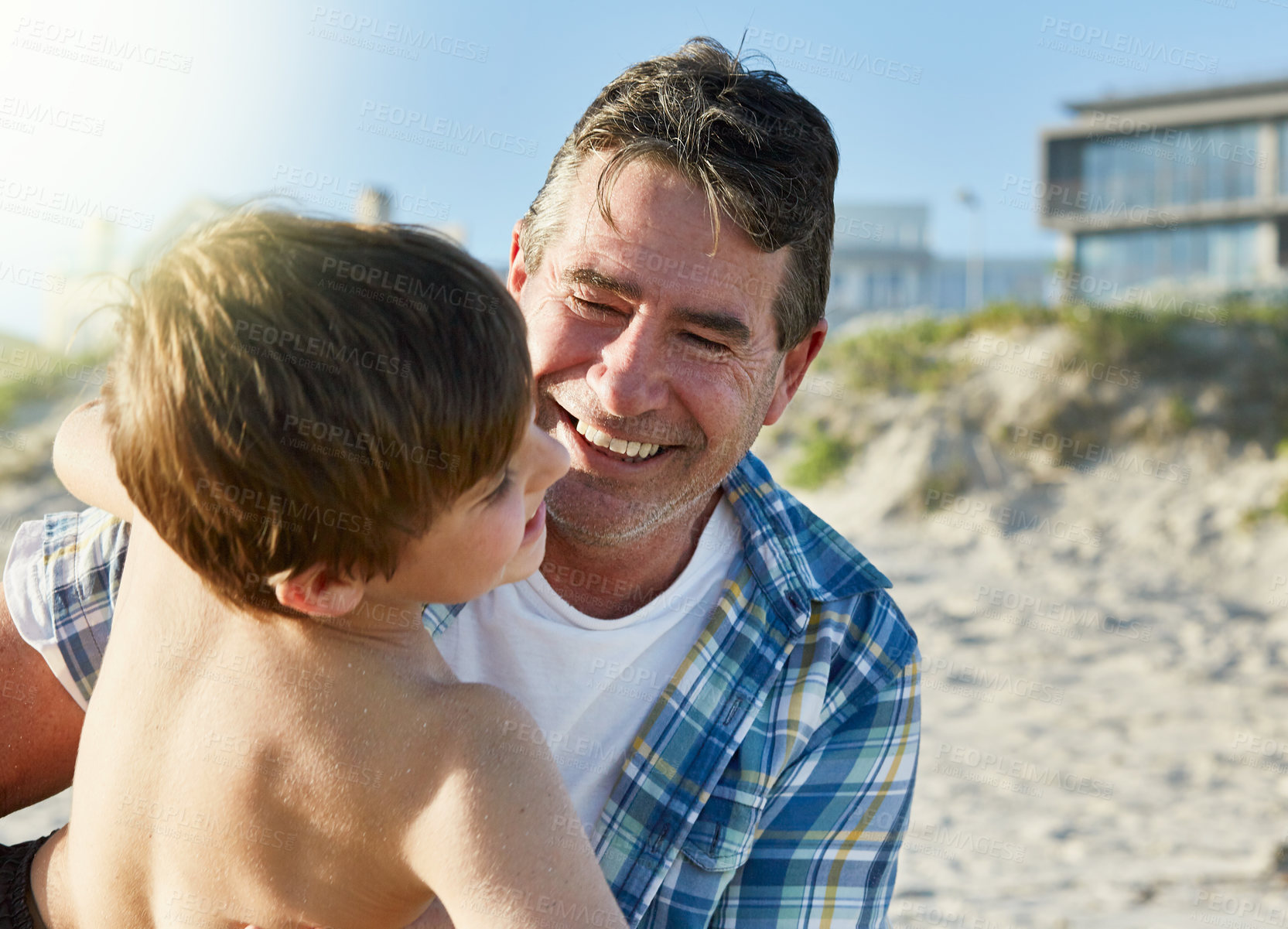 Buy stock photo Cropped shot of a father and son bonding together at the beach