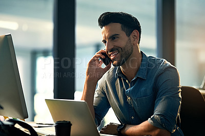 Buy stock photo Shot of a young businessman talking on his phone during a late night at work