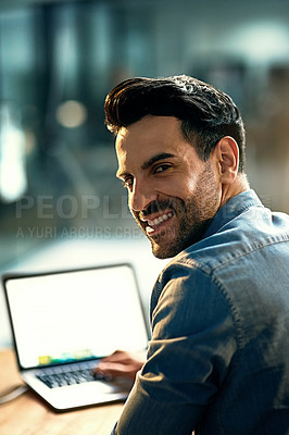Buy stock photo Portrait of a young businessman using a laptop during a late night at work