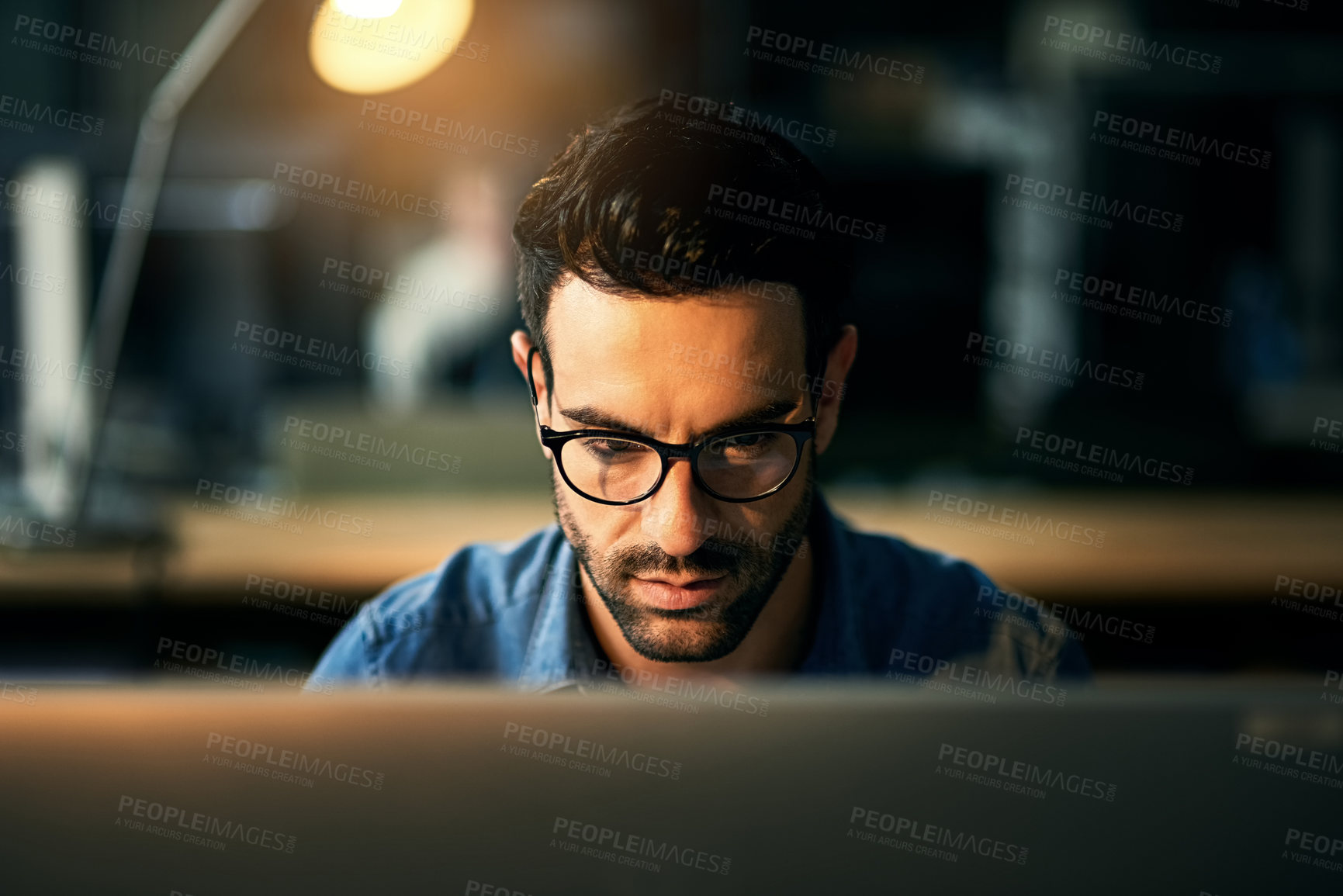 Buy stock photo IT guy working with computer late at night, searching online while planning, thinking strategy or typing out deadline. Business man with glasses looking serious and concentrating in office