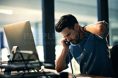 Buy stock photo Shot of a young businessman experiencing stress during a late night at work